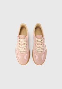 Roosad tossud seemisnahast ja nahast materjalist, millel on kreemikad paelad, ümar varvas ja helepruun kummist tallaosa.