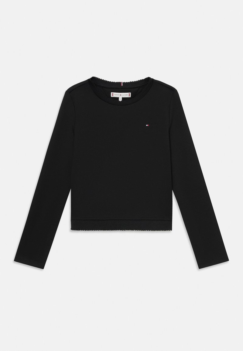 Czarna bluzka z długim rękawem, okrągłym dekoltem, skróconym fasonem, falbaniastym dołem oraz małym kolorowym logo na klatce piersiowej. Miękka tekstura materiału.