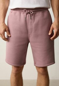 Pantalones cortos de mezcla de algodón en color rosa con cintura elástica, cordón y bolsillos laterales. Presentan una textura suave y un diseño de corte recto.