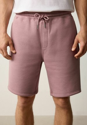 Shorts en mélange de coton rose avec taille élastique, cordon de serrage et poches latérales. Présente une texture lisse et un design à coupe droite.