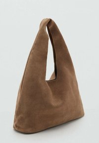 Hnedá semišová taška s jedinečným trojuholníkovým tvarom a jedným dlhým držadlom. Má hladkú textúru a minimalistický dizajn.