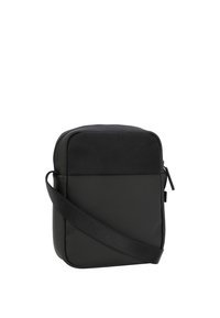 Borsa a tracolla nera realizzata in materiale liscio e resistente. Forma rettangolare con chiusura a zip e tracolla regolabile. Dettaglio del pannello superiore testurizzato.