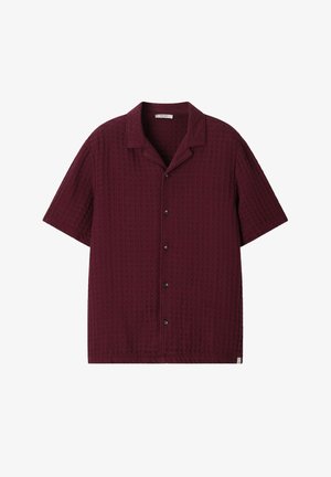 Chemise à manches courtes boutonnée en bordeaux foncé avec un motif en maille gaufrée texturée et un col camp.
