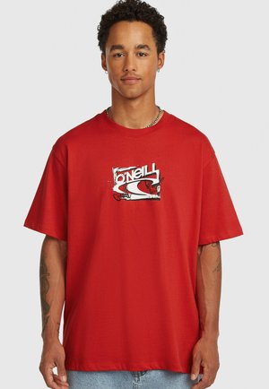 Červené bavlnené tričko s okrúhlym výstrihom a krátkymi rukávmi, s bielym grafickým logom v strede na hrudi. Voľný strih a mäkká textúra.