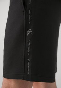 Calvin Klein Jeans LOGO REPEAT - Pantalones deportivos - black