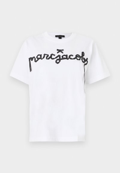 Λευκό T-shirt με κοντά μανίκια, με μαύρο κείμενο σε καλλιγραφικό στυλ "marc jacobs" στο στήθος και μια μικρή μαύρη λεπτομέρεια φιόγκου πάνω από το κείμενο.