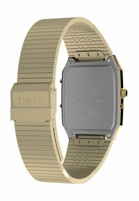 Montre en acier inoxydable Timex avec un bracelet flexible doré présentant un motif texturé. Boîtier rectangulaire avec un fond métallique et une couronne.