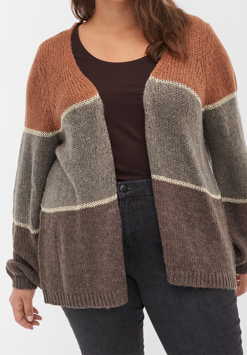 Cardigan de punto en colores marrón, gris y óxido con frente abierto, puños acanalados y acabado texturizado. Rayas horizontales superpuestas acentúan el diseño.