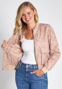 Lightweight beige bomber jacket with a smooth texture and subtle abstract pattern. Features ribbed cuffs, a zip front, and a pocket.