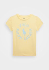 Camiseta amarilla de algodón, con mangas cortas y cuello redondo. Adornada con un logo circular azul que dice "POLO RALPH LAUREN."