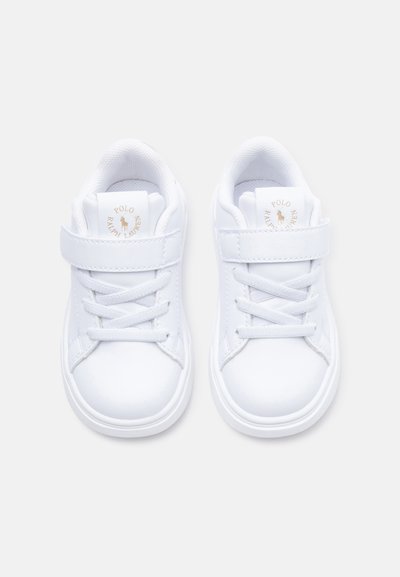 Par de zapatillas blancas para niños pequeños de Polo Ralph Lauren con cordones y tiras de Velcro, logo visible en las lengüetas, sobre un fondo gris.