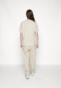 Nike Sportswear W NSW ESSNTL PANT FLC TREND - Calças de fato de treino - sanddrift/white