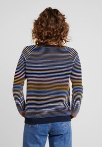 Stickad tröja med flerfärgade ränder i blått, gult och rosa. Har en rund halsringning samt ribbade ärmslut och nederkant.