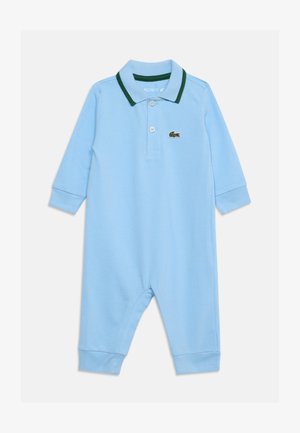 Barboteuse bébé bleu clair à manches longues, avec col polo bordé de vert et deux boutons, arborant un petit logo crocodile vert sur la poitrine.