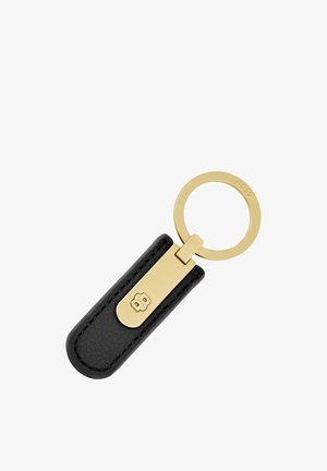 Zwarte leren sleutelhanger met gouden metalen ring en sluiting, met een reliëflogo op de sluiting en de merknaam gegraveerd op de ring.