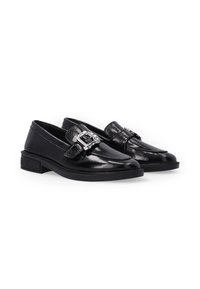 Zwarte gepatineerde leren loafers met een vierkante neus, zilveren gespdetail en lage blokhak, met een gladde textuur en strakke lijnen.