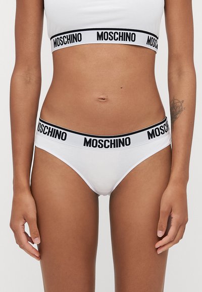 Bela bombažna bikinica z širokim črnim pasom, na katerem je napis "MOSCHINO" v belem tisku, gladka tekstura in klasična oblika.