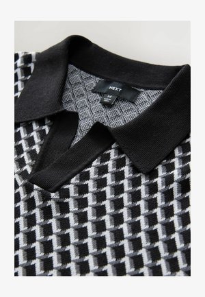 Black and grey patterned polo shirt with a textured design, ribbed collar, and label showing size M and brand name "NEXT."