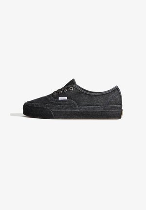 Sneaker in denim nero con design a taglio basso, punta tonda e chiusura con lacci. Presenta una tomaia strutturata, cuciture a contrasto e suola in gomma.