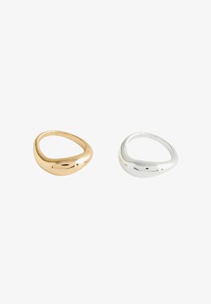 Two smooth, irregularly shaped rings, one gold and one silver, displayed on a white background.