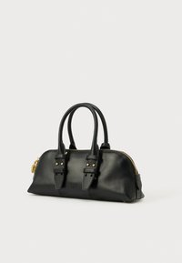 Mala de mão em couro preto com duas alças superiores, fecho de correr dourado e tachas douradas. Forma arredondada com textura lisa e detalhe de marcação discreto.