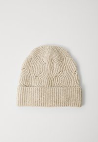 Crèmekleurige gebreide beanie met geribbelde omgeslagen rand en een textuur met golvende patronen op het lijf, plat gelegd op een witte ondergrond.