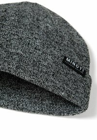 Pletená čiapka v šedých odtieňoch s textúrovaným vzorom. Má čiernu etiketu s nápisom "MINOTI OUTDOOR EDITION" na okraji.