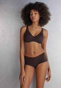 Hnědá bezdrátová podprsenka a set s vysokým pasem, hladká tkanina, bezešvý design, minimalistický styl, široké ramínka a elastický pas.