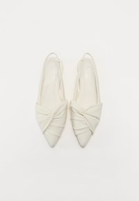 White slingback heels with a pointed toe, twisted fabric design, smooth texture, and minimalistic silhouette. No visible hardware accents.