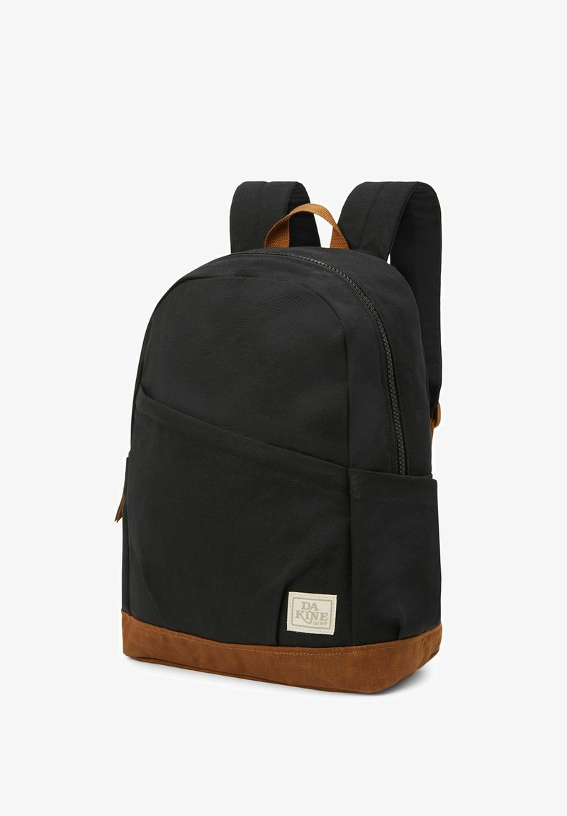 Zwarte stoffen rugzak met een bruine suède bodem. Beschikt over een hoofdvak met rits, gevoerde schouderbanden en een klein voorvak. Logo patch zichtbaar.