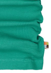 Tessuto turchese a coste con una superficie testurizzata, che mostra delle pieghe. Presenta un piccolo etichetta multicolore sul bordo.
