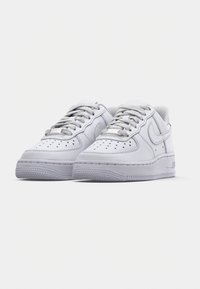 Pair of white low-top athletic sneakers with perforated toe box, lace-up design, and textured rubber soles on a plain white background.