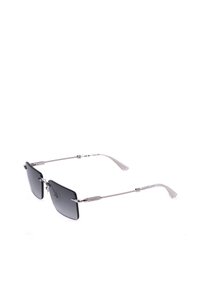 Lunettes de soleil rectangulaires noires sans monture avec des branches fines en métal argenté et des embouts texturés en plastique transparent sur fond blanc.
