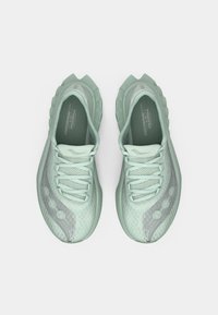 Light mint green athletic shoes with a textured mesh upper, minimalist design, lace-up closure, and a segmented outsole for traction.
