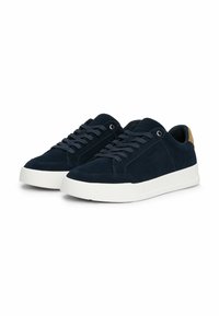 Navy suede sneakers with a white rubber sole, featuring round laces, embroidered logo, and a tan accent on the heel.