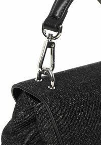 Sac en bandoulière noir texturé avec une sangle en cuir lisse noire, des accessoires en acier inoxydable et un fermoir métallique pour une fixation sécurisée.