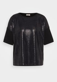 Černý top s krátkými rukávy, který má lesklý panel z flitrů vpředu a na rukávech a zádech je z jednolité černé látky, kombinující textury a lesk.