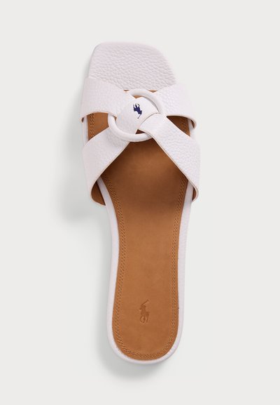 Sandal com tiras cruzadas brancas, upper texturizado, detalhe circular e palmilha castanha. Apresenta logótipo em relevo na sola e sola lisa.