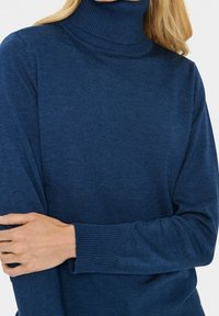 Granatowy sweter golfowy wykonany z prążkowanej dzianiny, z długimi rękawami i dopasowaną linią szyi. Gładka faktura z minimalistycznym wzornictwem.