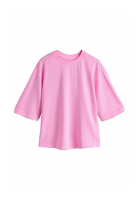 T-shirt oversize à manches courtes rose clair avec col rond, présenté sur un fond blanc uni.