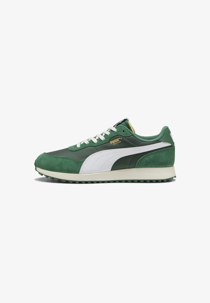 Groene en witte Puma Helsinki sneaker met witte veters, gouden logo, bovenwerk van suède en nylon, en een gestructureerde rubberen zool, zijaanzicht op een witte achtergrond.