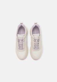 Sneaker Calvin Klein in crema e lavanda con lacci, colli imbottiti e suole interne con marchio, viste dall'alto su uno sfondo bianco.