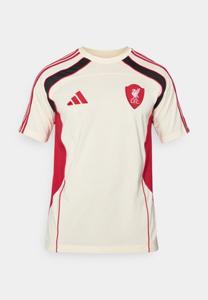 Jasnokremowa koszulka sportowa z czerwonymi i czarnymi akcentami, logo Adidas oraz emblematem Liverpool Football Club. Krótkie rękawy z detalem trzech pasków.
