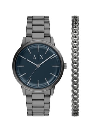 Herrenuhr aus schwarzem Metall mit dunkelblauem Zifferblatt und silbernen Stundenmarkierungen, neben einem schwarzen Metallkettenarmband gezeigt.