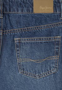 Jeans in denim blu scuro con cuciture ben visibili. Presentano una piccola tasca posteriore e un'etichetta in pelle marrone chiaro con la scritta "Pepe Jeans London."