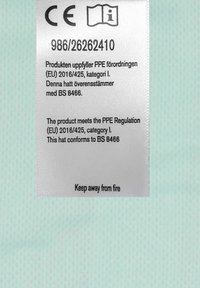 Vit klistermärke med säkerhetsinformation, med text på engelska och svenska, som innehåller en varning "Håll borta från eld".