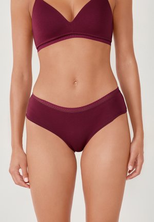 Ensemble de soutien-gorge bourgogne et culottes taille haute, fabriqué en tissu doux avec une texture lisse et des coutures décoratives le long des bords.