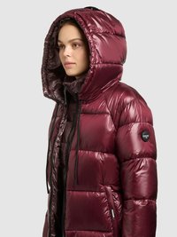 Bordo värvi õhuga täidetud jope sädeleva viimistlusega, polsterdatud disain, suur kapuuts, nöörlukk ja küljetaskud. Varrukal on logo.