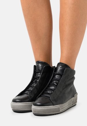 Sneakers alte in pelle nera con finitura texturizzata, dotate di chiusura frontale con zip, dettagli con lacci e suola in gomma grigia.