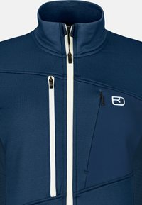Marineblaue Jacke mit strukturiertem Finish. Verfügt über einen hohen Kragen, weiße Reißverschlüsse und mehrere Reißverschlusstaschen. Logo auf der Brust.